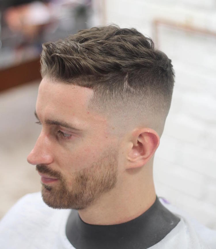 Corte de pelo corto para hombre con pelo ondulado y un desvanecimiento calvo en los lados