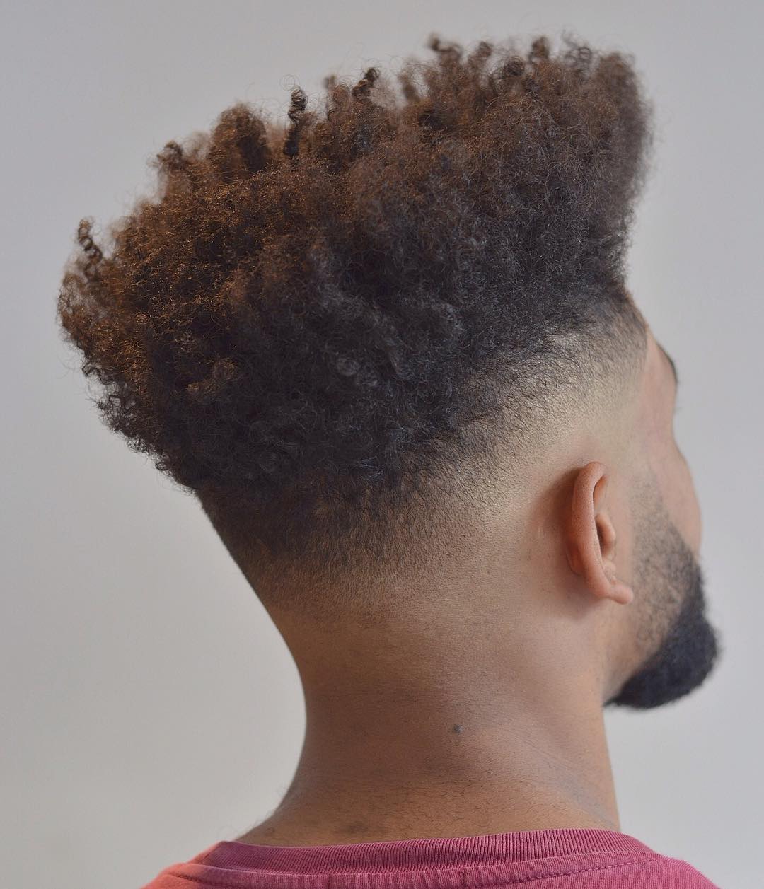 Low bald fade on sides with long natural curls on top 