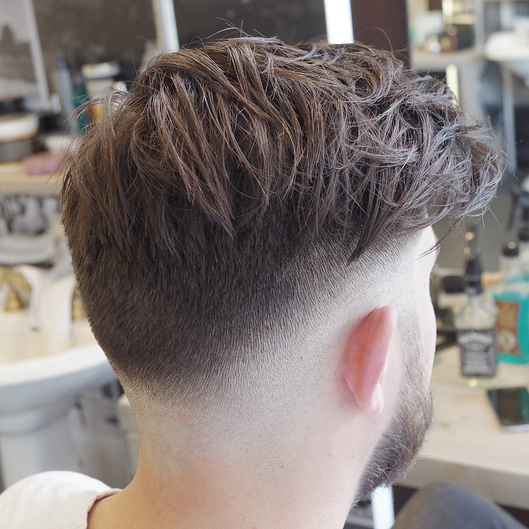 Low bald fade and messy mens hairstyle on top