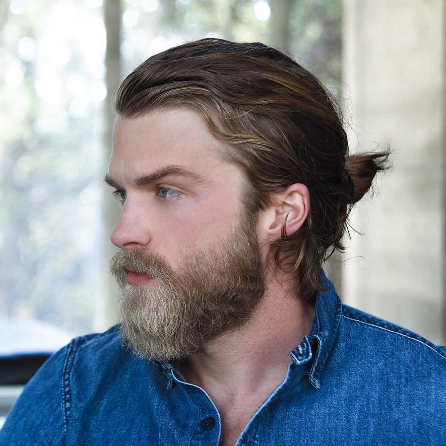 Long hair pulled back into a man bun