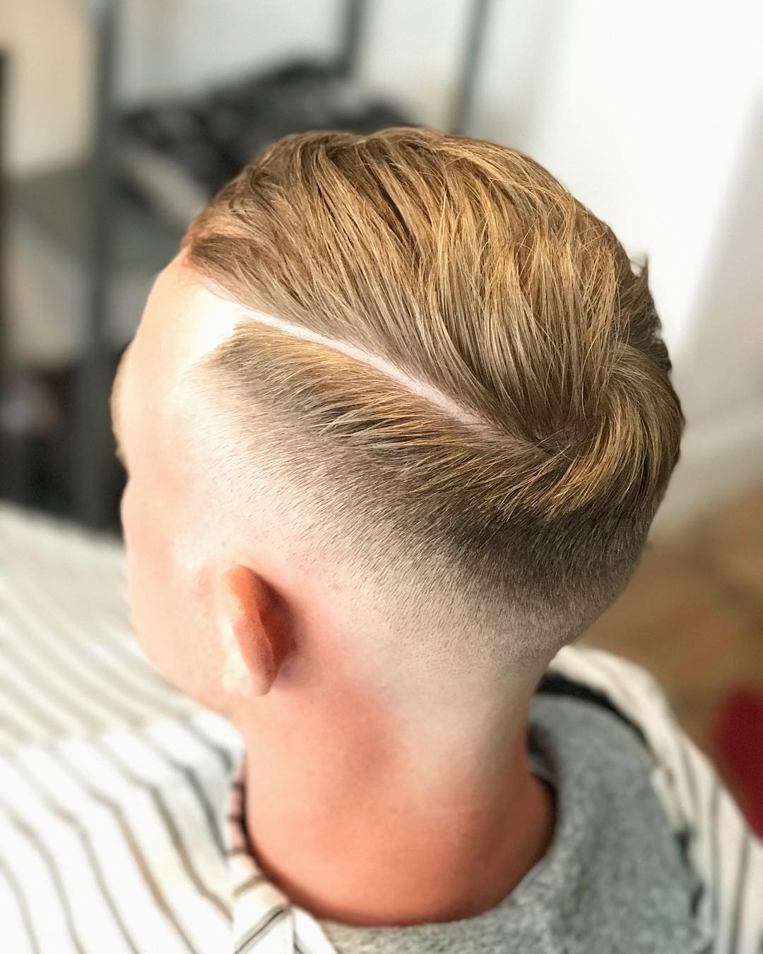 Comb over haircut with mid fade and hard part