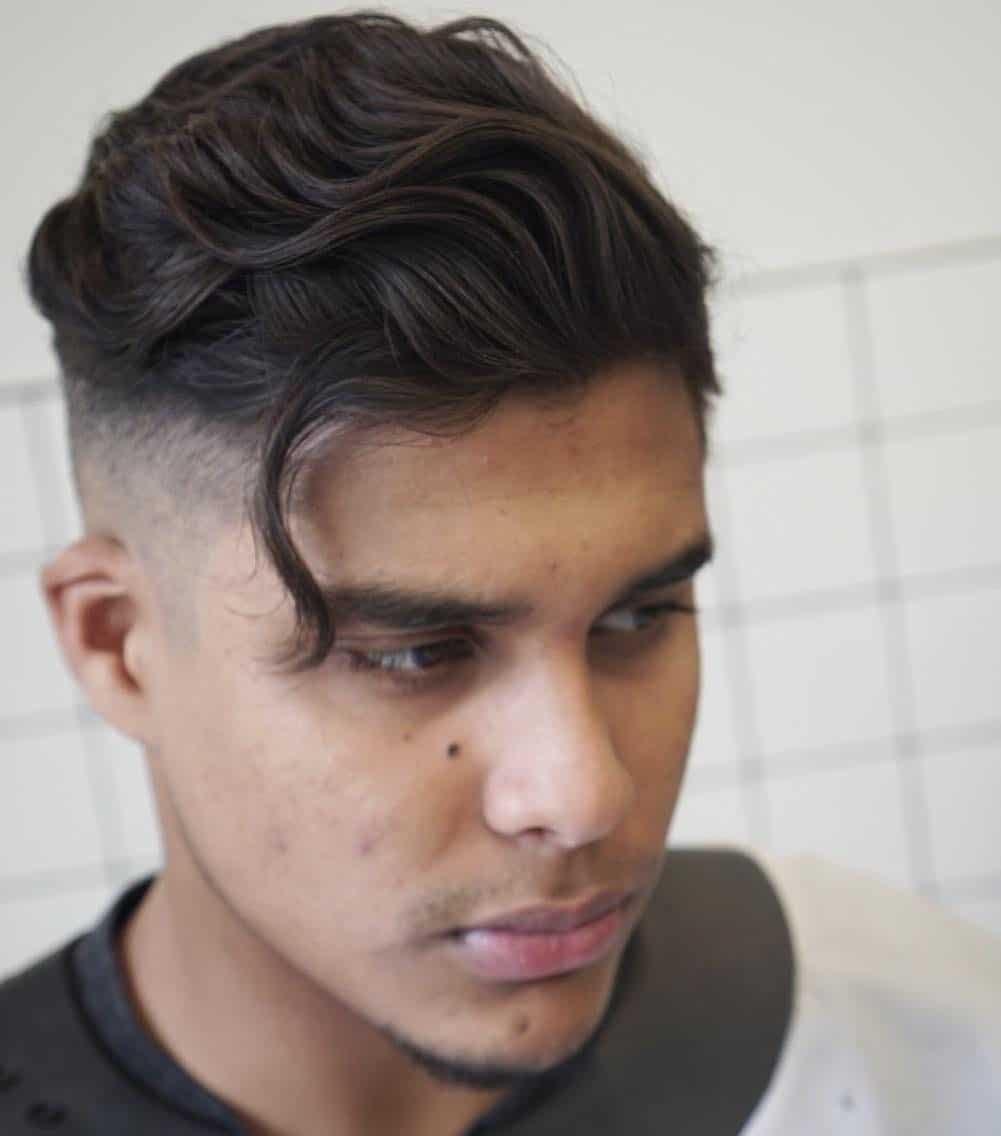 Mid fade haircut with wavy hair