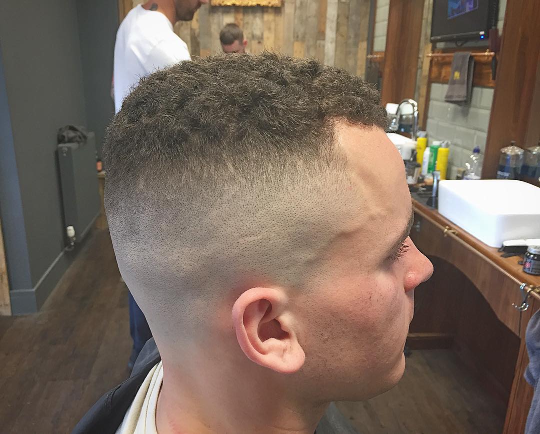 Curly hair high and tight with a bald fade