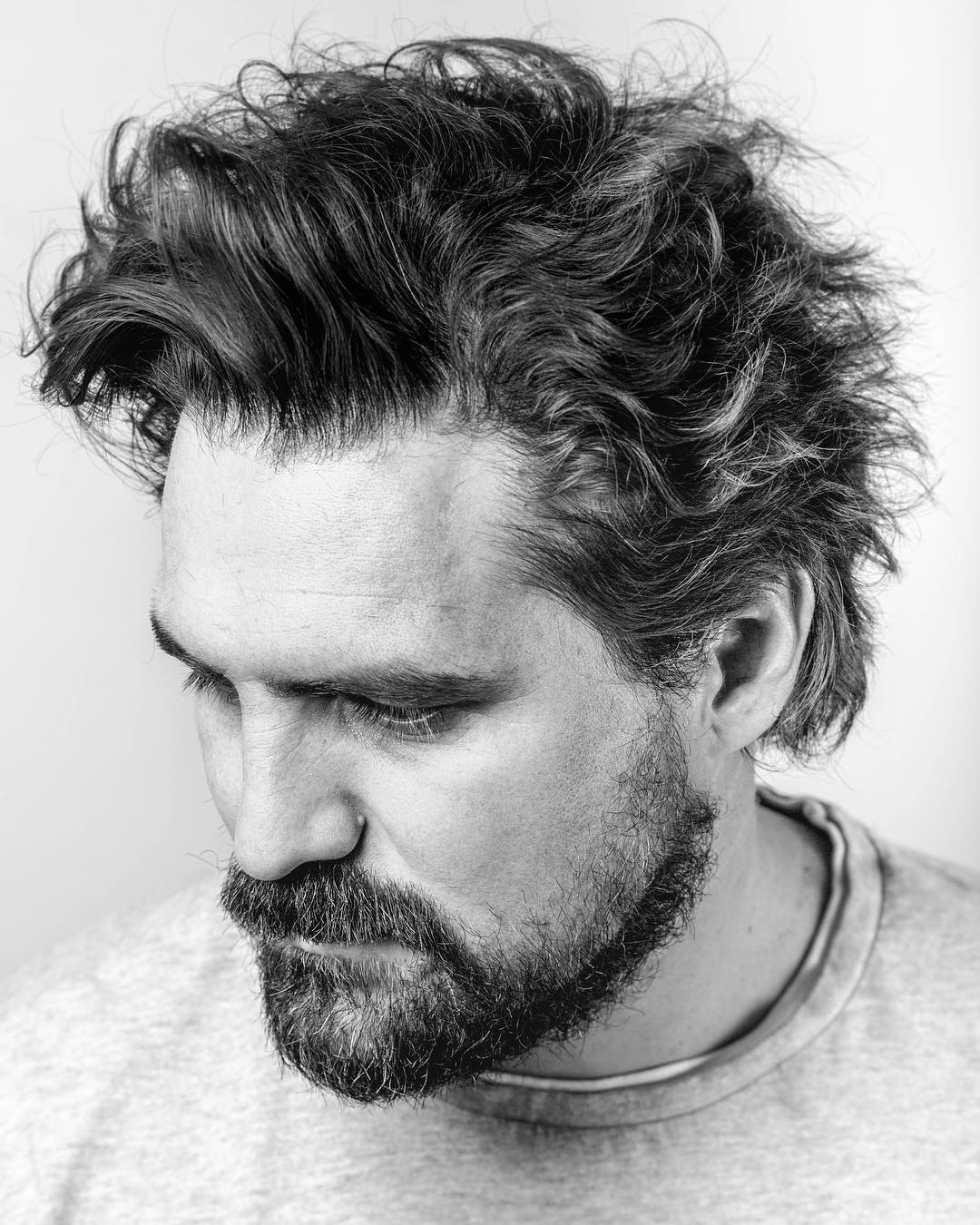 Wispy forward falling hair onto your face will soften your jaw line
