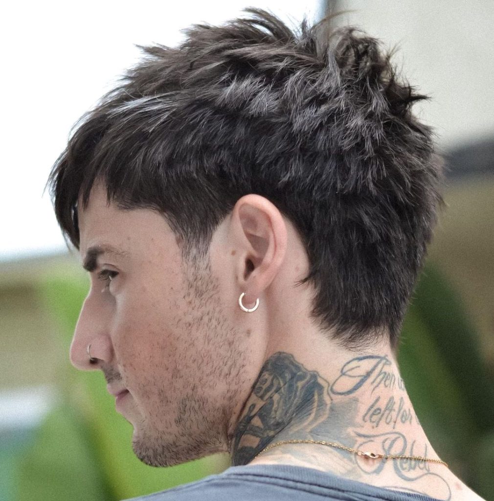Cool messy short haircut for man with piercings and neck tattoos